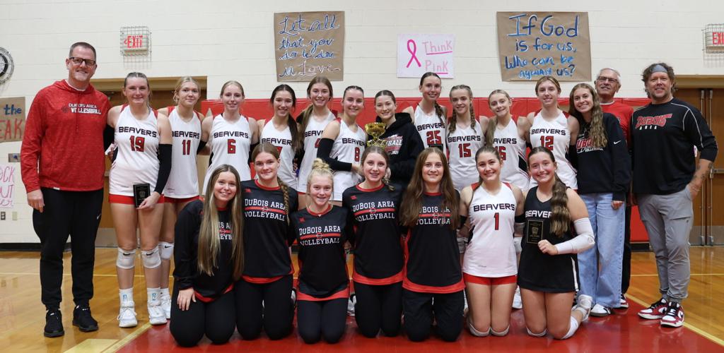 DuBois Area volleyball players and coaches posing with trophies in a gym.