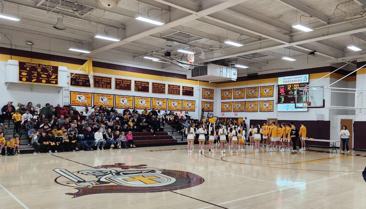 Students, athletes, and spectators in the Elk County Catholic Crusaders gymnasium.