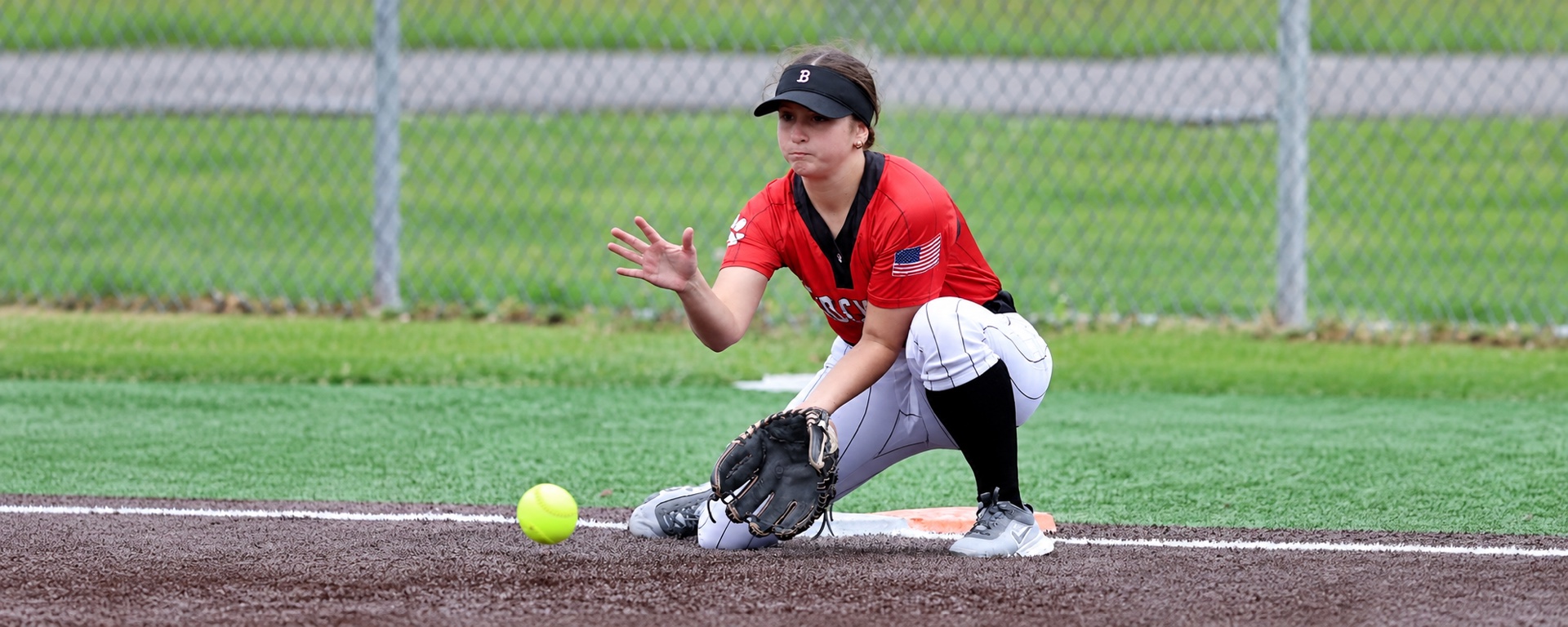 Softball player fielding a ground ball on the infield.